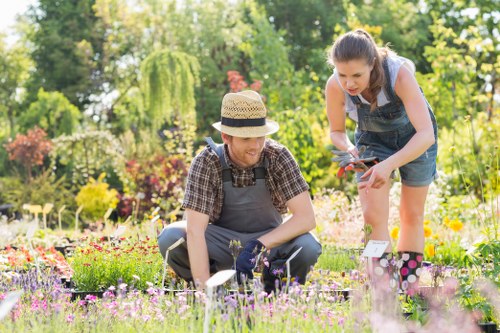 Gardener installing eco-friendly irrigation system in Cleaners SW20