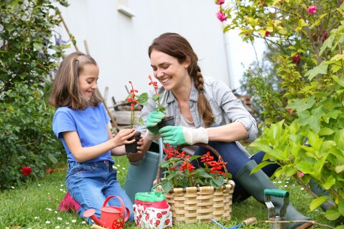 Professional lawn mowers maintaining a pristine green garden in Cleaners SW20